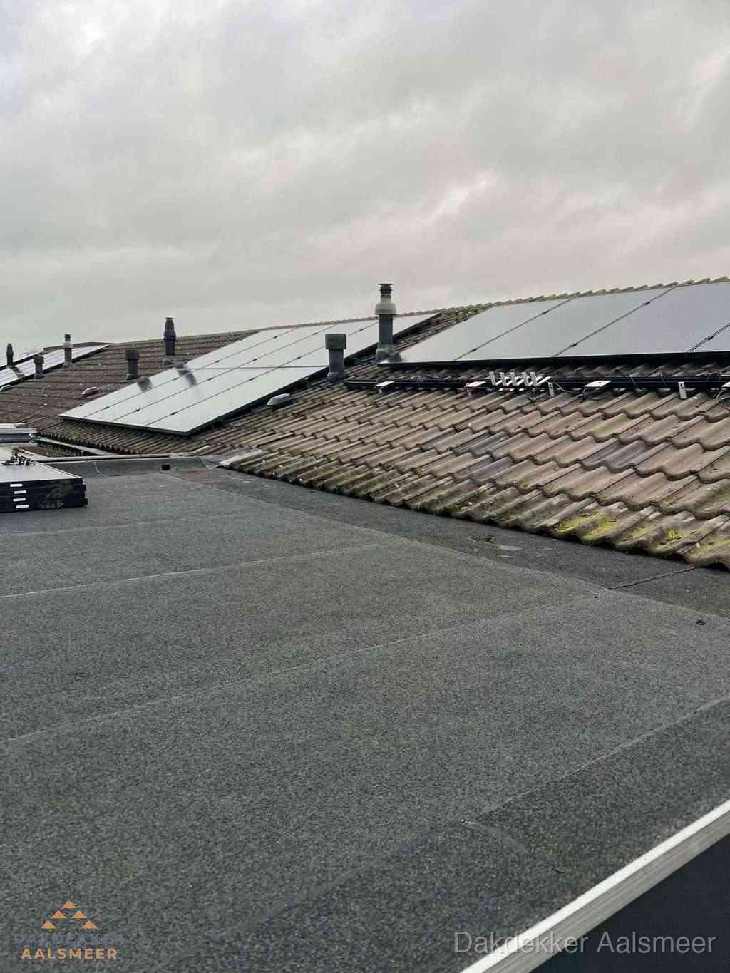 Plat dak inspectie met bitumen bedekking naast schuin pannendak in Aalsmeer