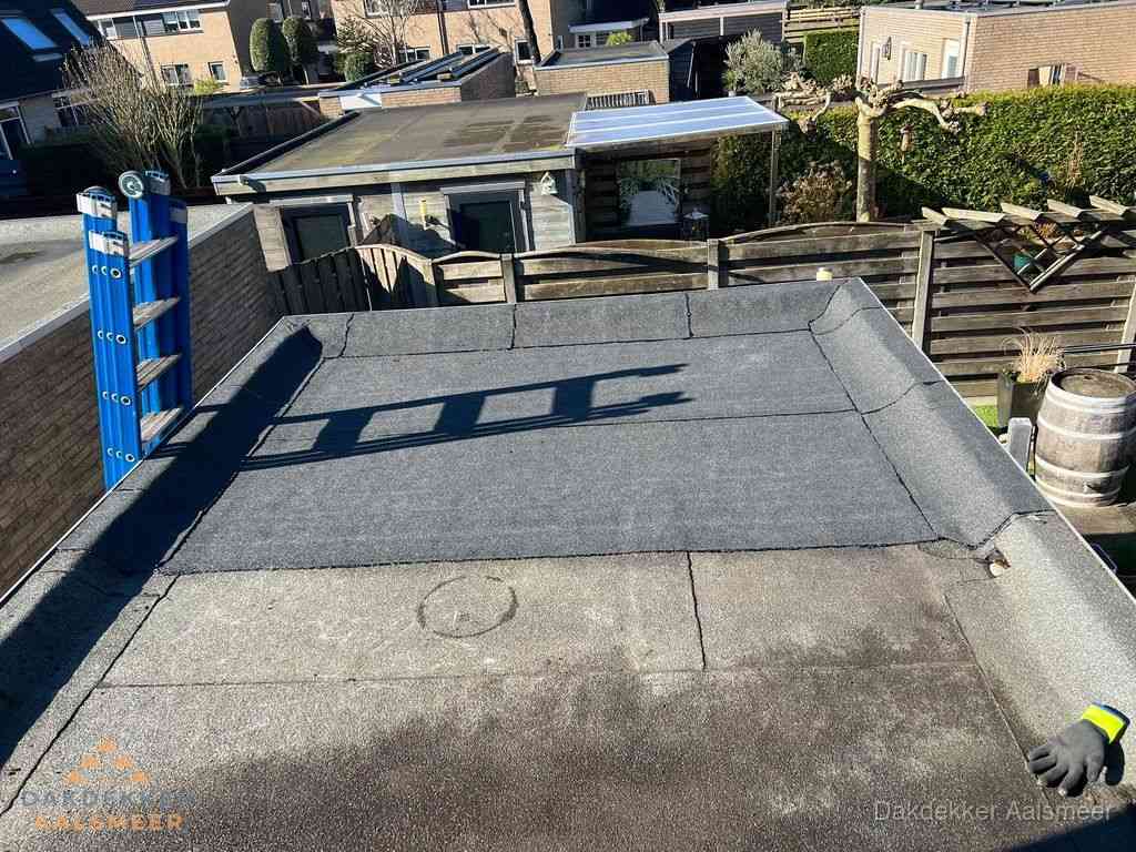 Dakdekker legt onderlaag op plat dak met houten constructie in Aalsmeer