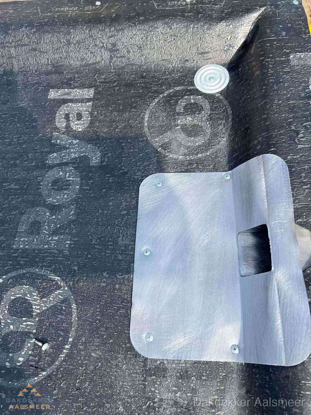 Dakdoorvoer met metalen afvoerplaat op bitumen dak in Aalsmeer
