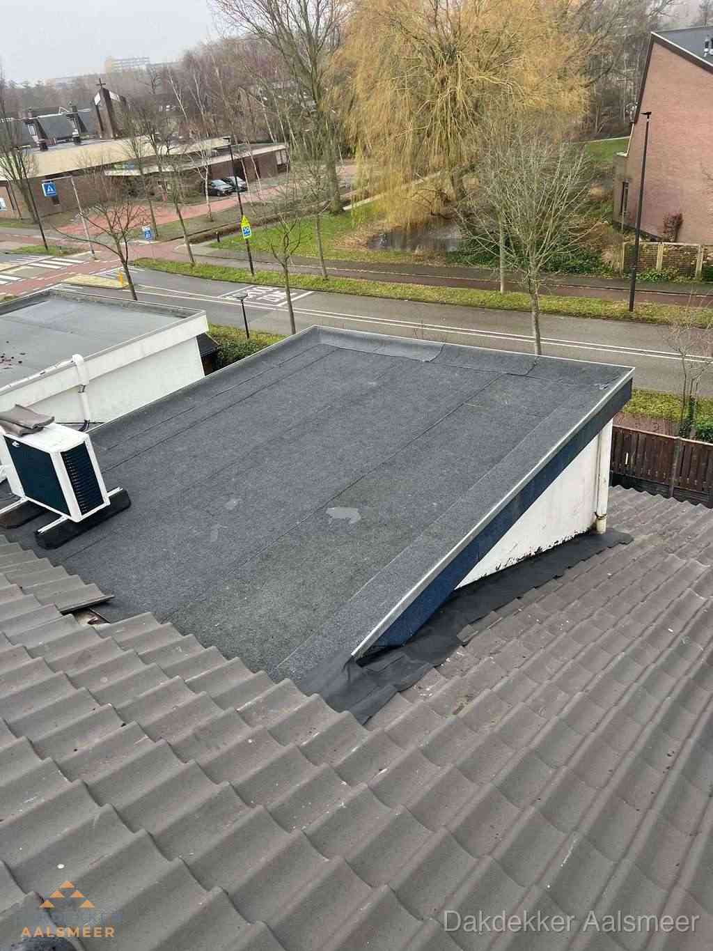 Plat dak met bitumen dakbedekking naast schuin pannendak in Aalsmeer