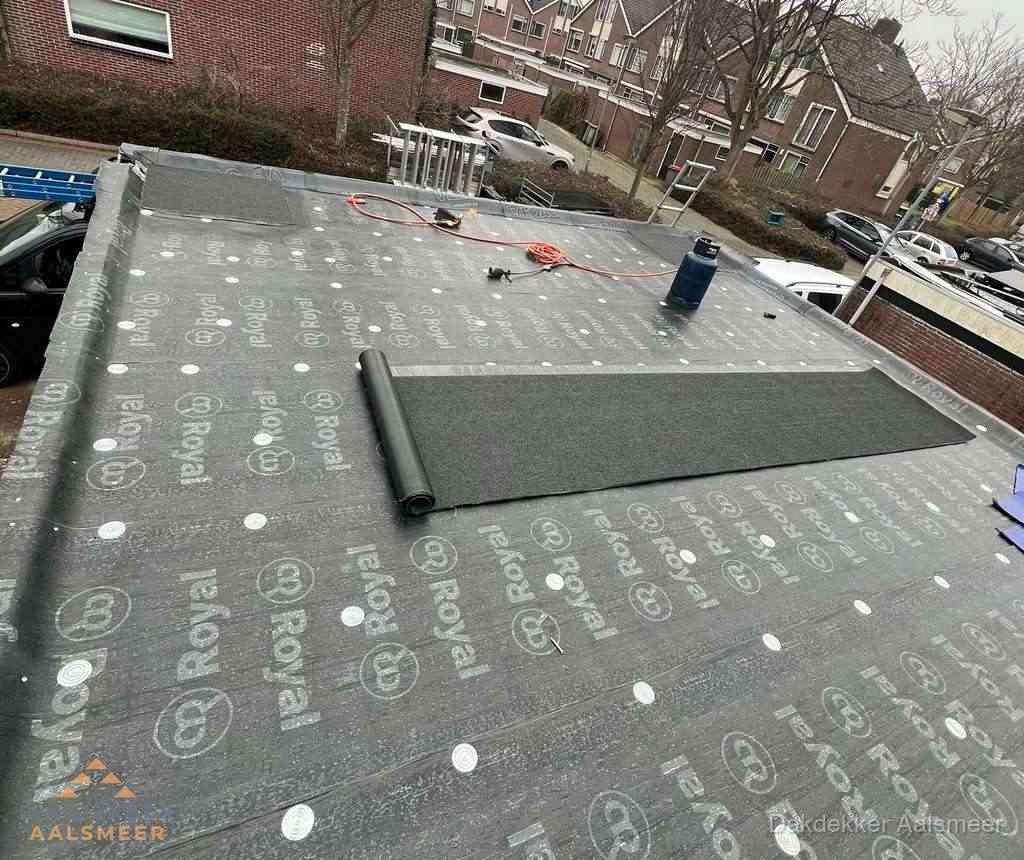 Dakdekker aan het werk met gasbrander op plat bitumen dak in Aalsmeer