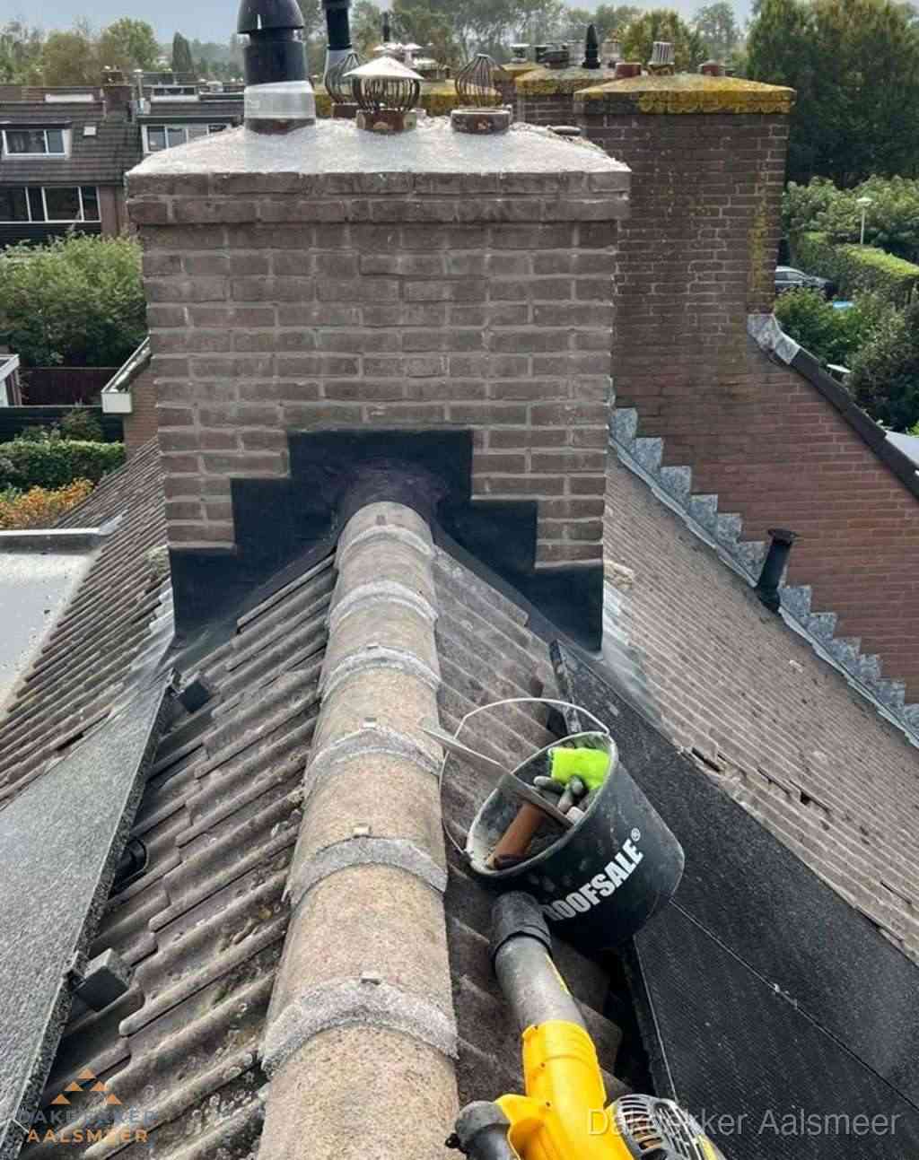 Dakdekker repareert bitumen dakleer bij dakdoorvoer in Aalsmeer
